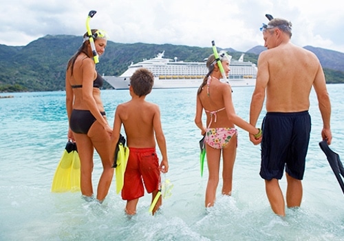 Gezin op het strand met cruiseschip op achtergrond Tijdens_een_cruise_verveel_je_je_nooit!-27